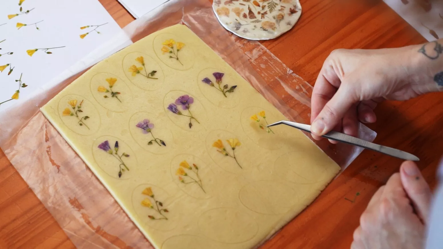 Aplicação cuidadosa de flores sobre a massa